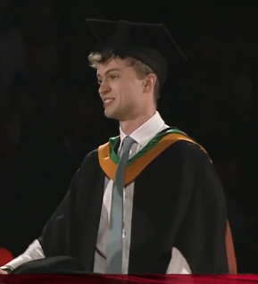 Harry Gilbert in a graduation robe.